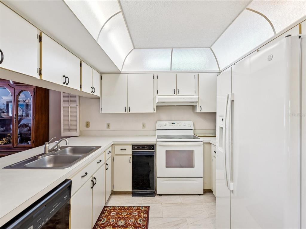 12141 Spartan Way, Unit 202 Hudson, FL 34667 - Photo 6 of 45 a kitchen with stainless steel appliances granite countertop a sink a stove and refrigerator