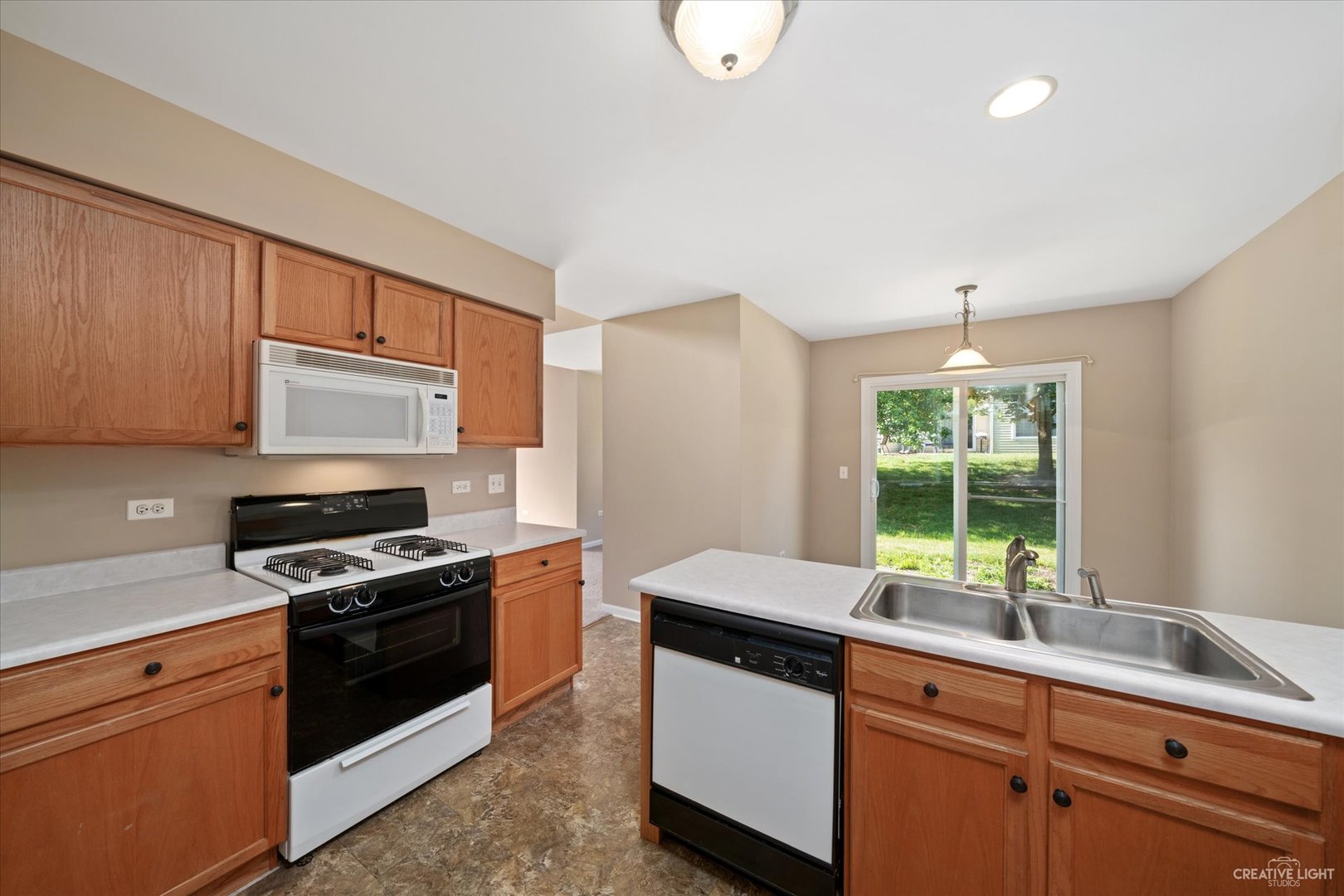 47 Rolling Oaks Road, Unit F Sugar Grove, IL 60554 - Photo 9 of 21 a kitchen with granite countertop stainless steel appliances a stove sink and microwave
