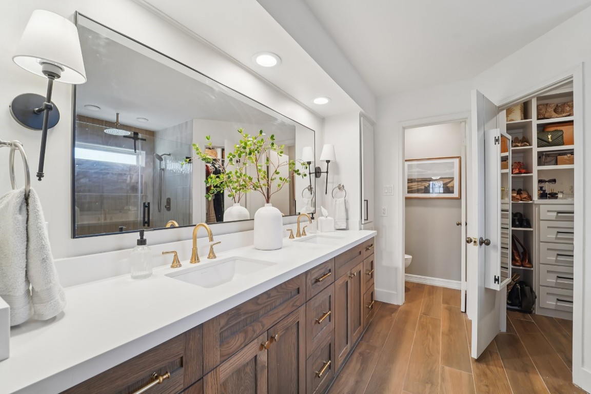 8307 Ash Valley Drive Spring, TX 77379 - Photo 19 of 48 Recently renovated primary bathroom featuring a new double vanity with quartz countertops and extensive built-in storage, including multiple drawers, cabinetry, and a dedicated hamper.