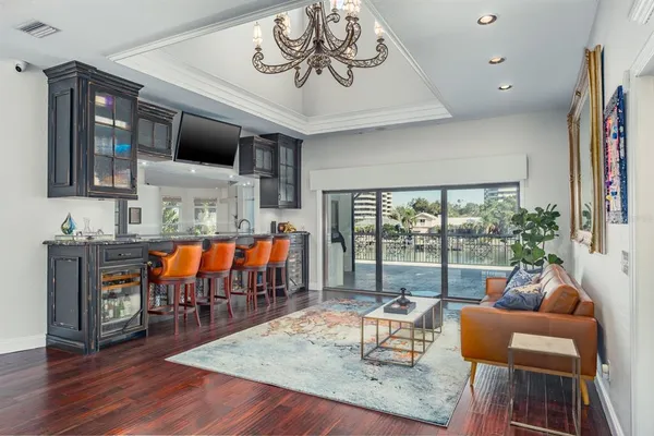 a living room with furniture a flat screen tv and floor to ceiling window