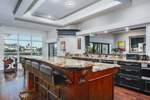 a kitchen with stainless steel appliances granite countertop table chairs and wooden floor