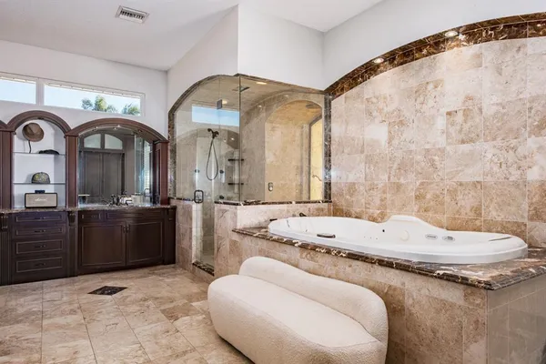a bathroom with a tub sink and mirror