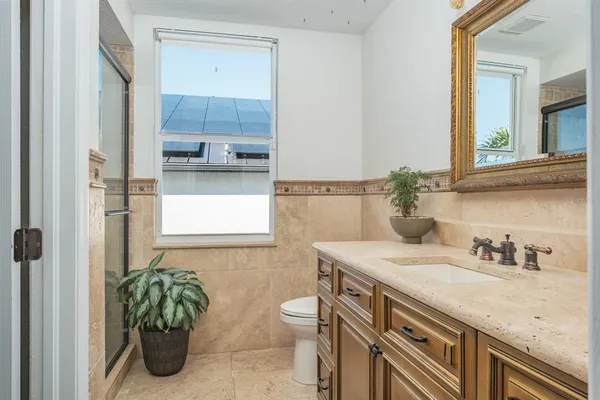 a bathroom with a granite countertop sink a toilet and mirror