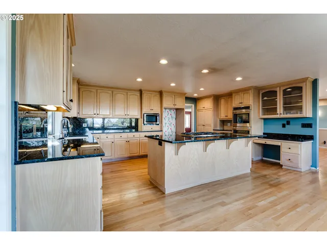 a large kitchen with stainless steel appliances kitchen island granite countertop a large counter top and stainless steel appliances