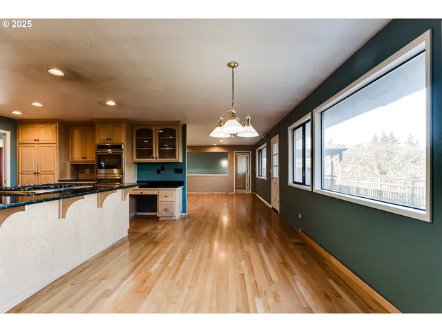 a view of empty room with wooden floor and fireplace