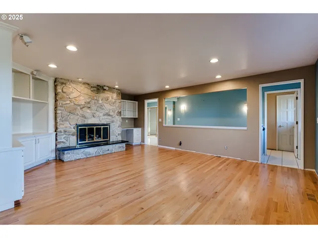a view of a room with an empty space and wooden floor