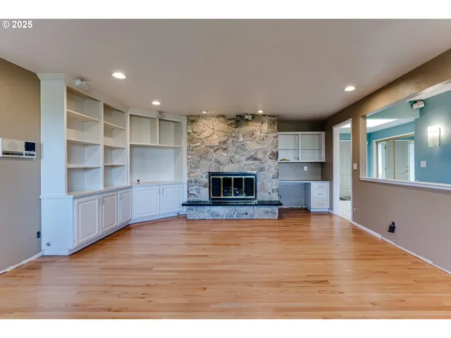a view of empty room with wooden floor and fireplace