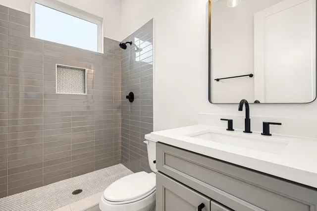 a bathroom with a sink a toilet and shower