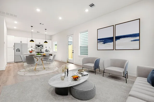 a living room with furniture and a dining table with kitchen view