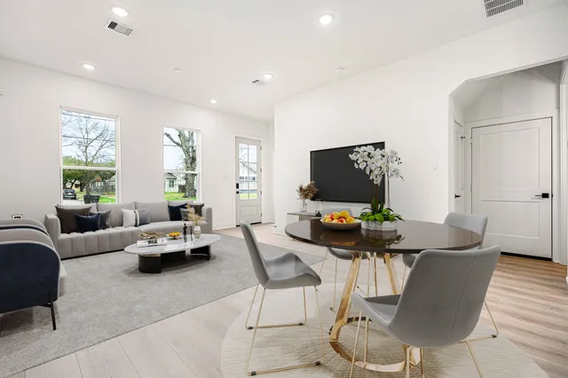 a living room with furniture a flat screen tv and a window
