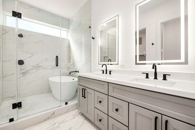 a bathroom with a double vanity sink a toilet a mirror and shower