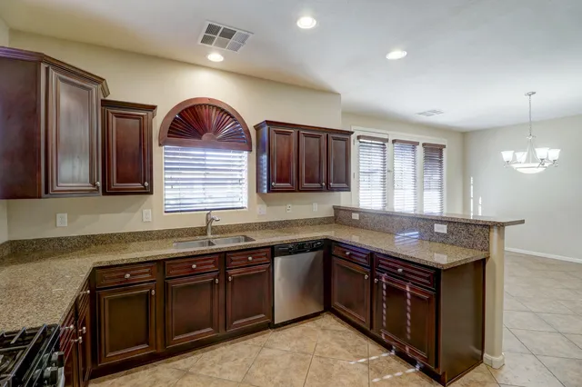a kitchen with kitchen island granite countertop a sink stainless steel appliances and cabinets