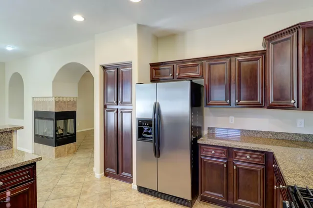 a kitchen with stainless steel appliances granite countertop a refrigerator and a stove