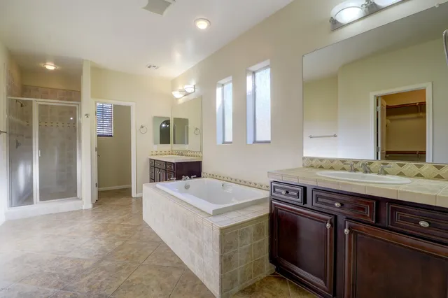 a spacious bathroom with a granite countertop sink and a mirror