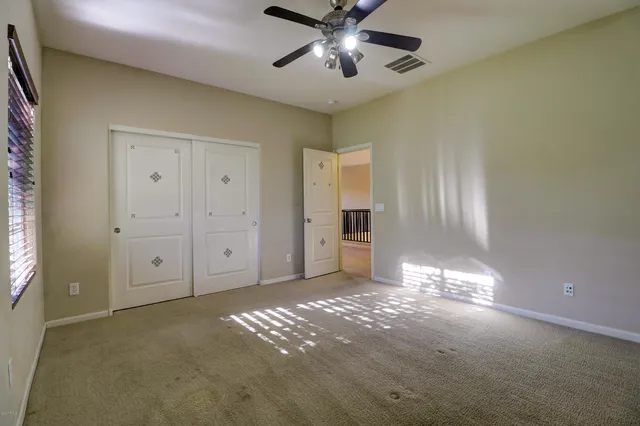a view of a livingroom with a chandelier fan and windows