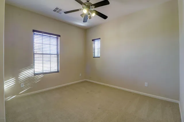 an empty room with a window and a ceiling fan