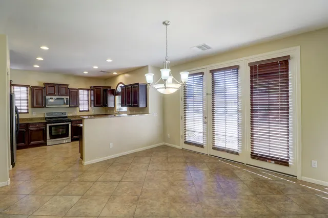 a kitchen with stainless steel appliances kitchen island granite countertop a refrigerator and a sink