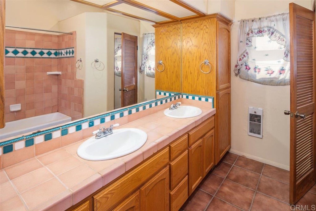 2061 Sycamore Drive San Marcos, CA 92069 - Photo 19 of 27 a bathroom with a granite countertop sink and a mirror
