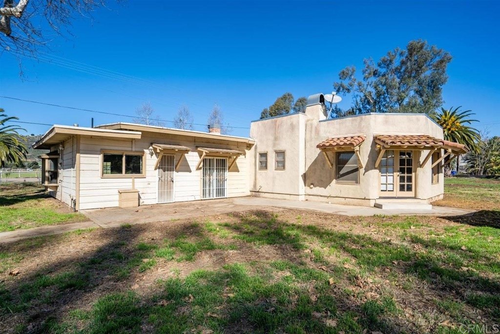 2061 Sycamore Drive San Marcos, CA 92069 - Photo 5 of 27 a view of a white house with a big yard and large trees