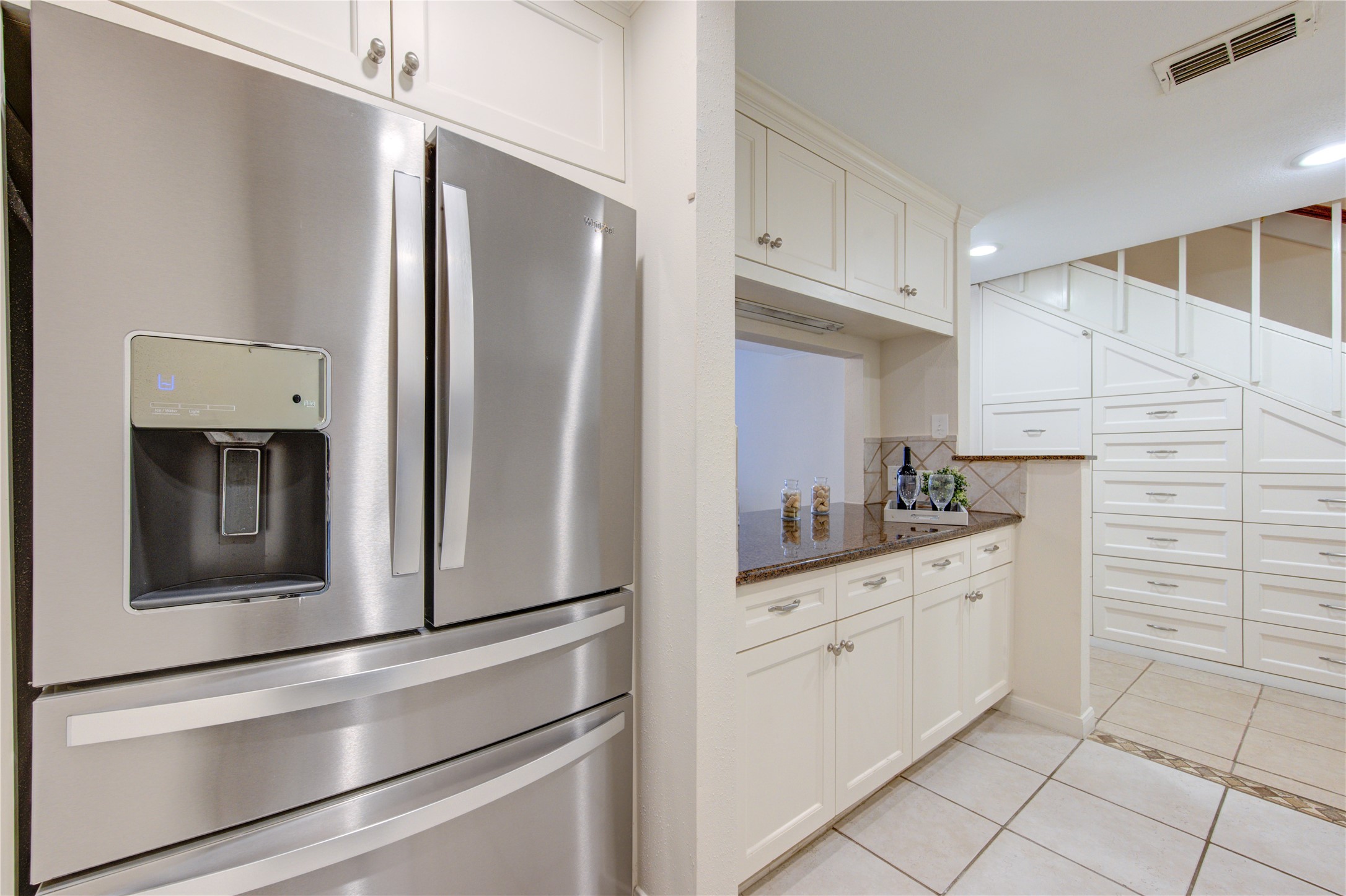 2232 South Piney Point Road, Unit 110 Houston, TX 77063 - Photo 6 of 21 Updated kitchen featuring extensive custom cabinetry, granite countertops, and an almost brand-new stainless steel refrigerator, plus exceptional built-in storage throughout the home.
