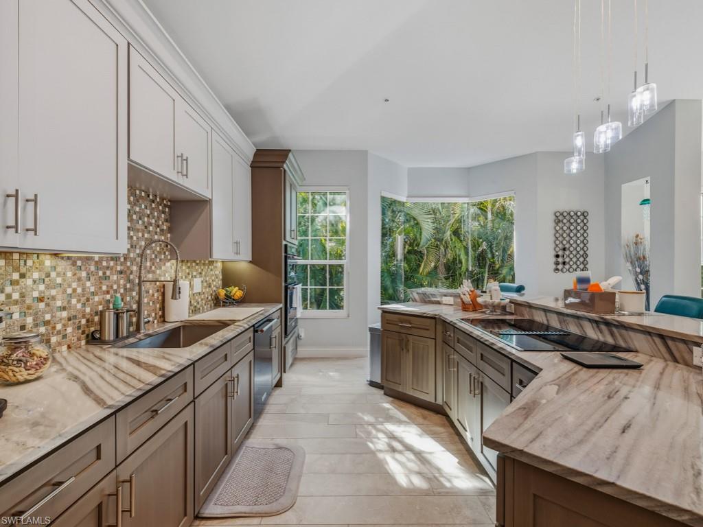 175 Colonade Circle Naples, FL 34103 - Photo 11 of 45 a large kitchen with kitchen island a large counter space a sink appliances and cabinets
