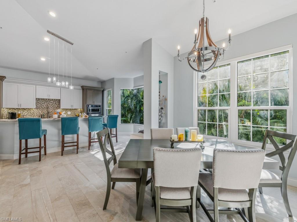 175 Colonade Circle Naples, FL 34103 - Photo 13 of 45 a dining room with furniture a chandelier and a rug