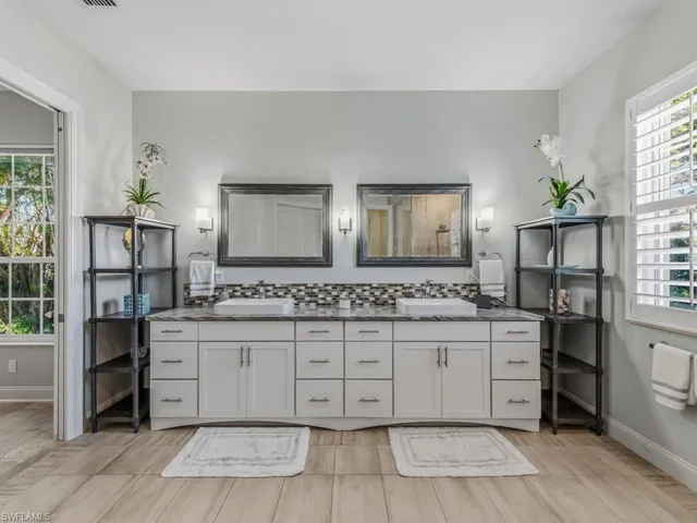 a spacious bathroom with a granite countertop sink and a mirror