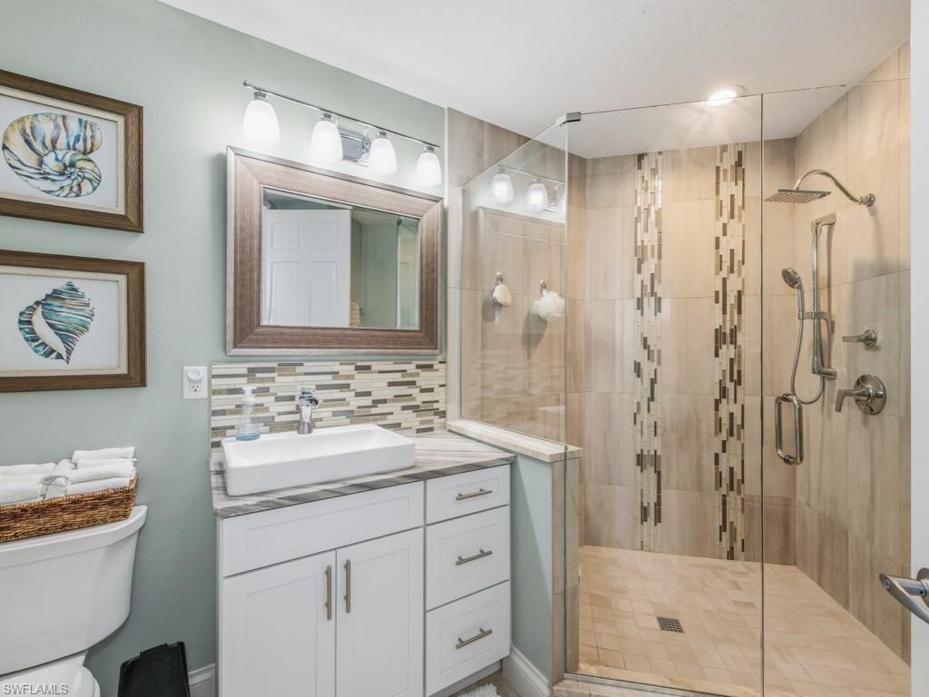 175 Colonade Circle Naples, FL 34103 - Photo 29 of 45 a bathroom with a shower sink vanity and mirror