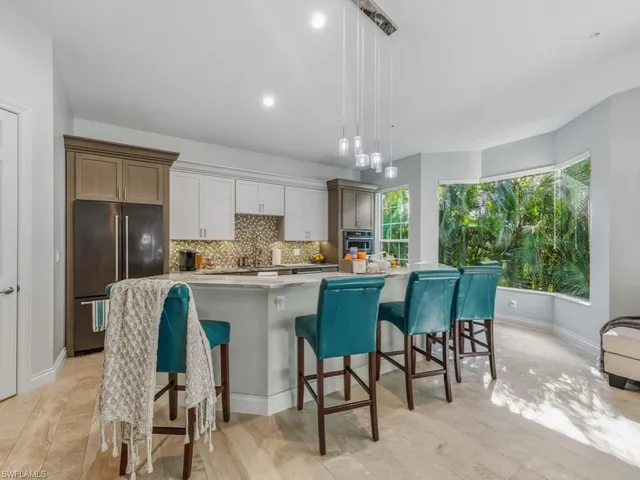 a kitchen with a table chairs refrigerator and cabinets