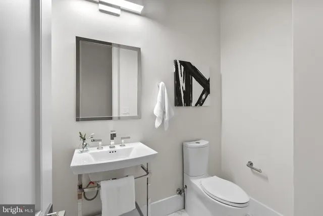 a bathroom with a toilet a sink and mirror