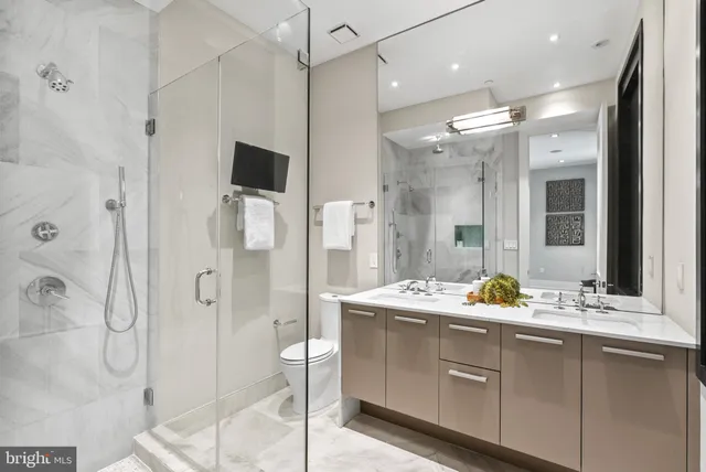 a bathroom with a double vanity sink mirror and shower