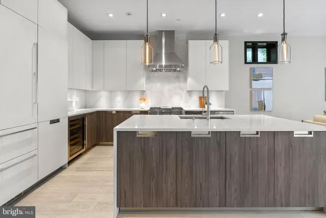 a kitchen with kitchen island granite countertop a sink a counter top space stainless steel appliances and cabinets