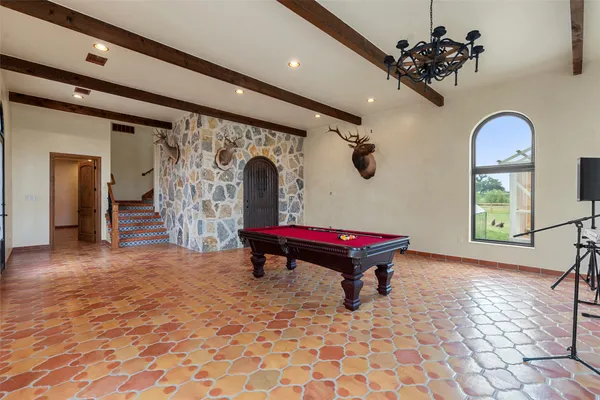 a living room with furniture a chandelier and a large window