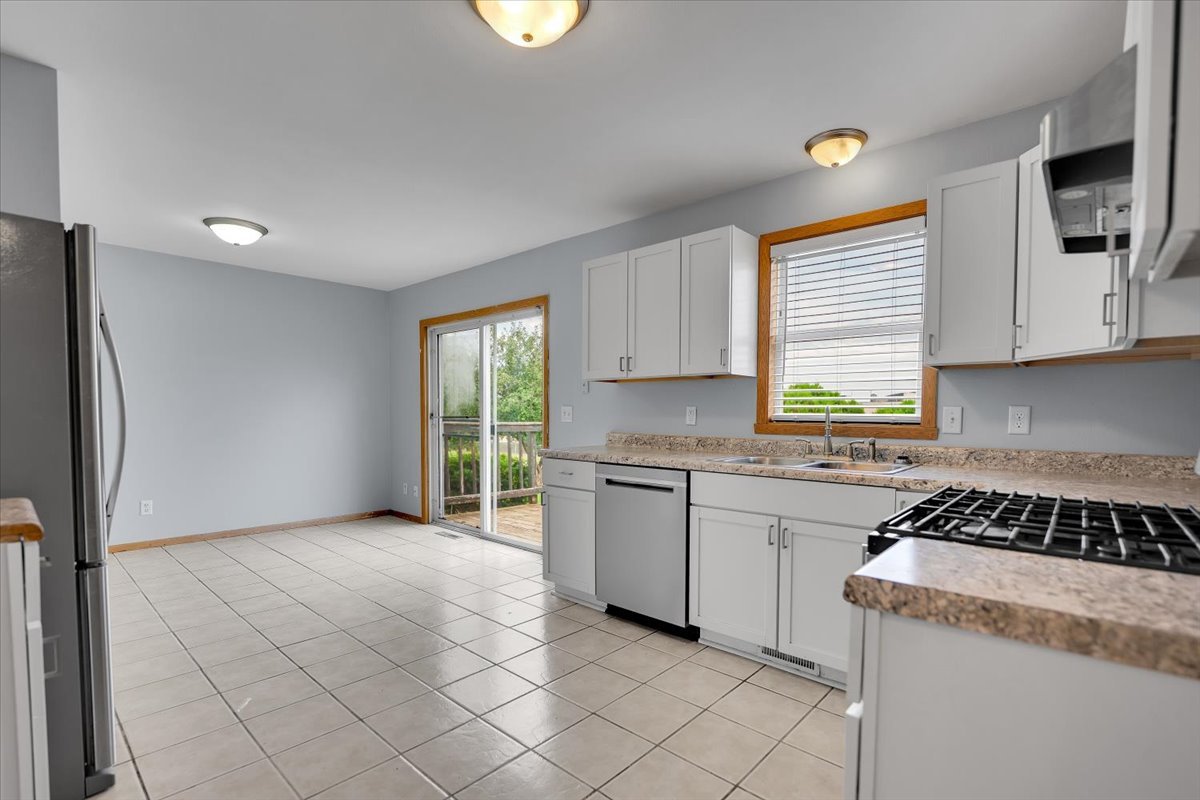 6621 Samantha Lane Rockford, IL 61107 - Photo 8 of 38 a kitchen with granite countertop white cabinets and window
