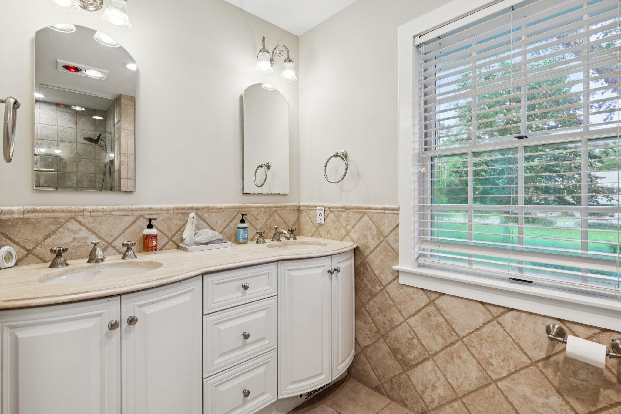 21 Inlet View Path East Moriches, NY 11940 - Photo 16 of 40 Bathroom featuring tile walls, double vanity, tiled shower, and wainscoting