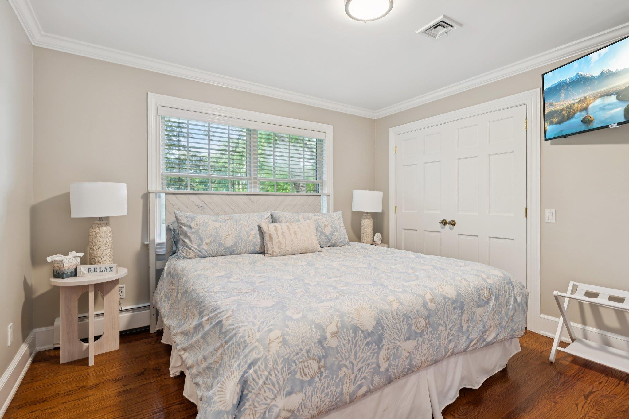 21 Inlet View Path East Moriches, NY 11940 - Photo 17 of 40 Bedroom featuring dark wood-style floors, ornamental molding, and a closet