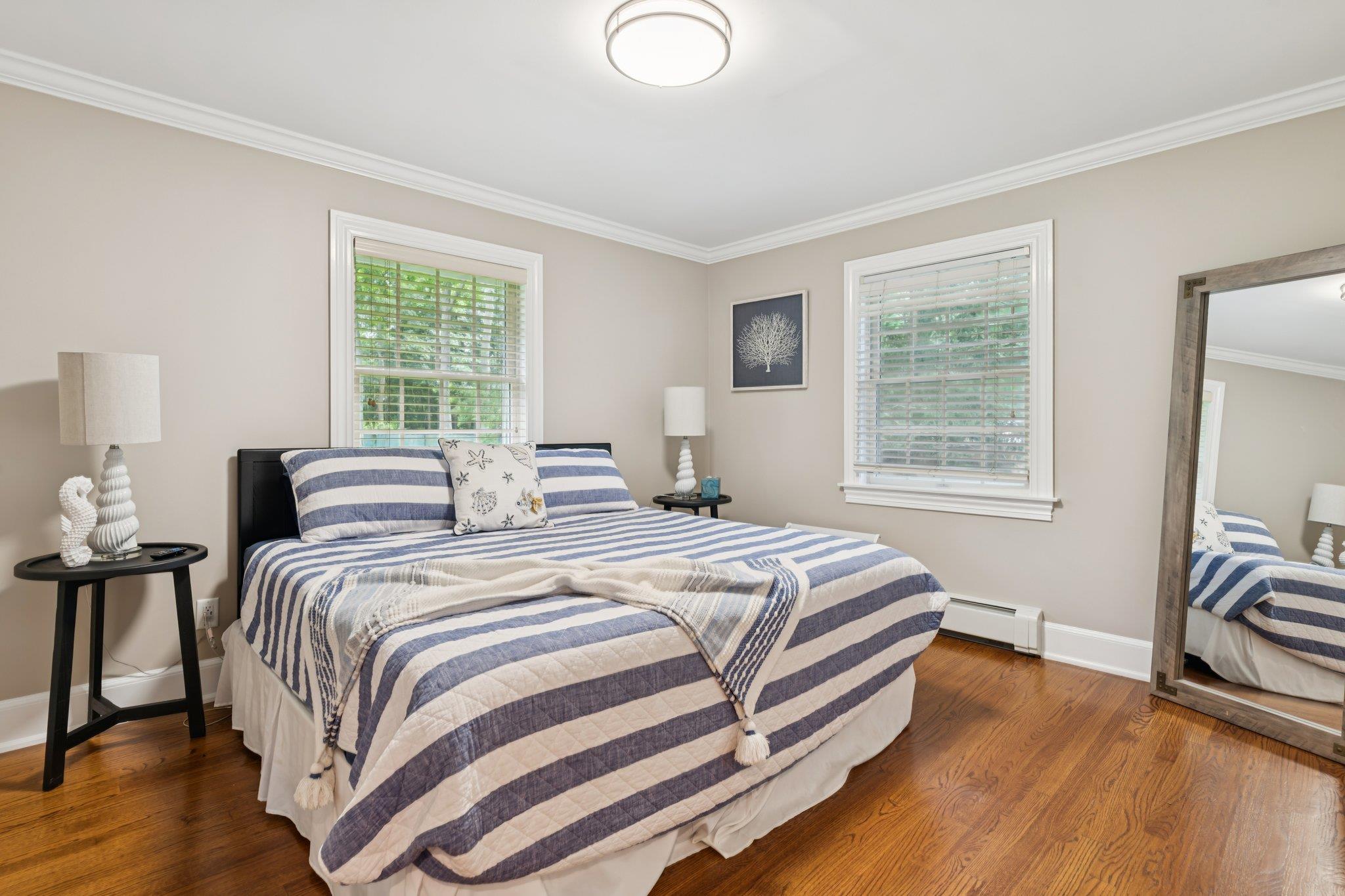 21 Inlet View Path East Moriches, NY 11940 - Photo 18 of 40 Bedroom featuring crown molding, multiple windows, wood finished floors, and a baseboard radiator