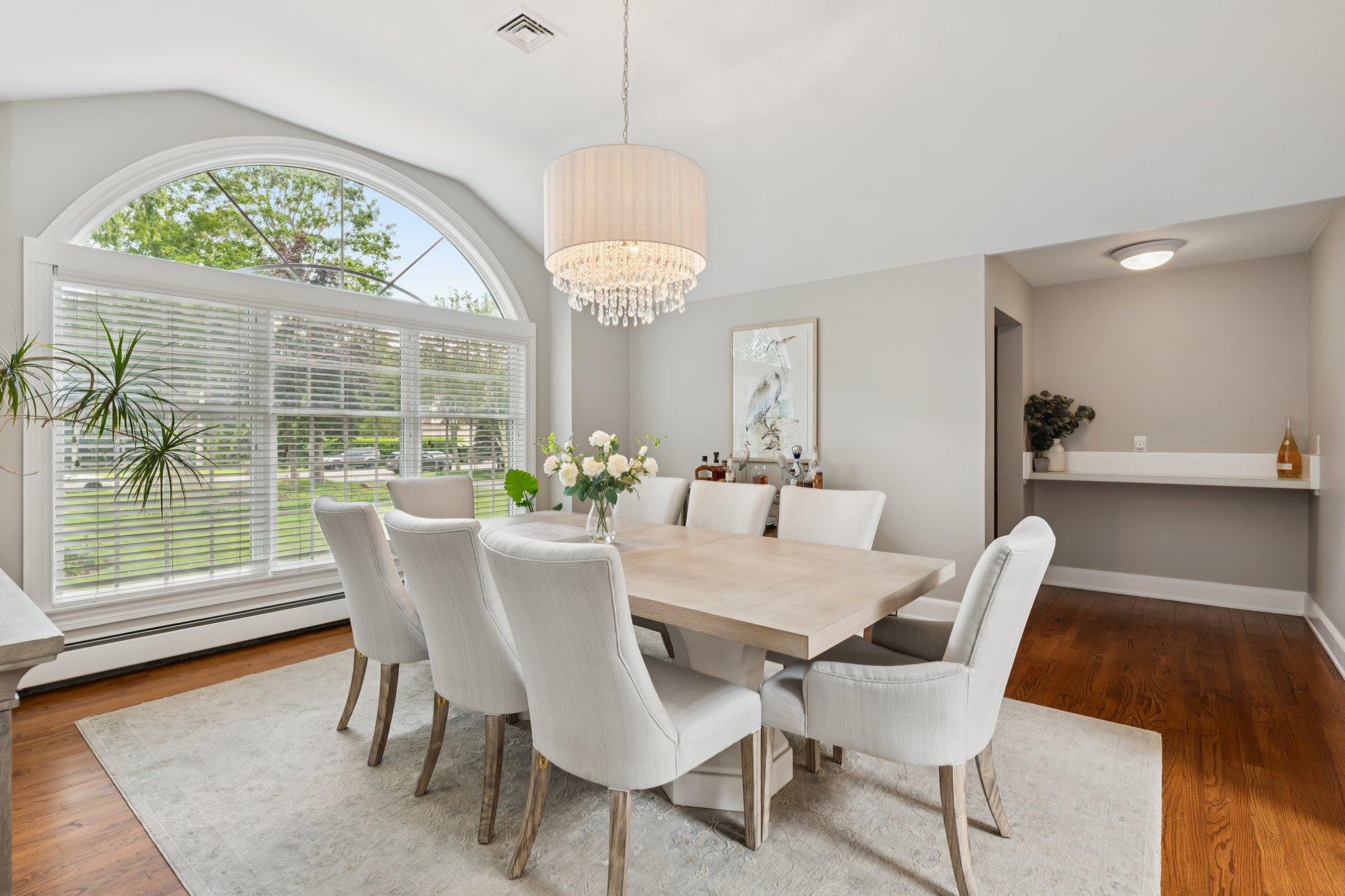 21 Inlet View Path East Moriches, NY 11940 - Photo 8 of 40 Dining space featuring lofted ceiling, a baseboard radiator, wood finished floors, and a chandelier