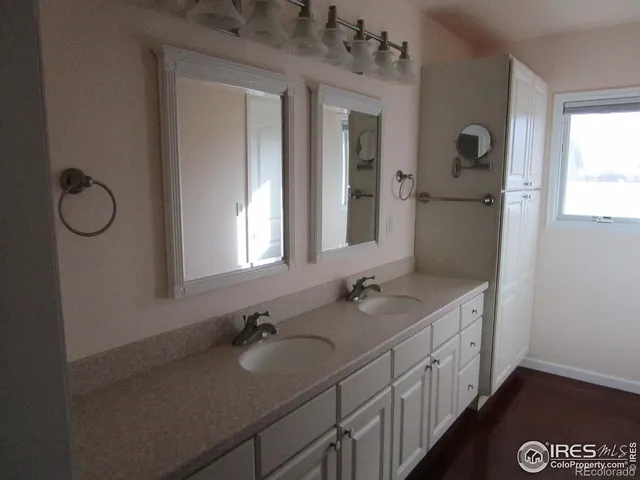 a bathroom with double vanity sinks a toilet a mirror and window