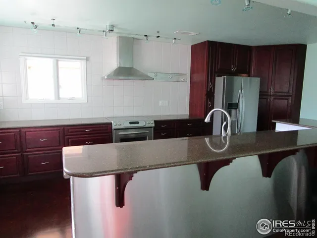 a kitchen with stainless steel appliances granite countertop a sink refrigerator and cabinets