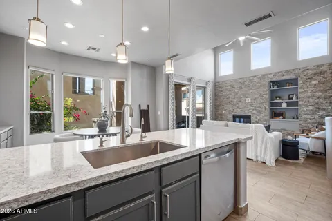 a kitchen with sink and view of living room