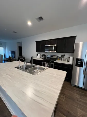 a kitchen with stainless steel appliances a refrigerator and a stove top oven