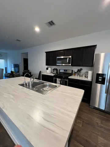 a kitchen with stainless steel appliances a refrigerator and a stove top oven