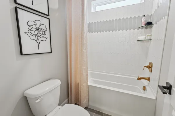 a white toilet sitting next to a bath tub