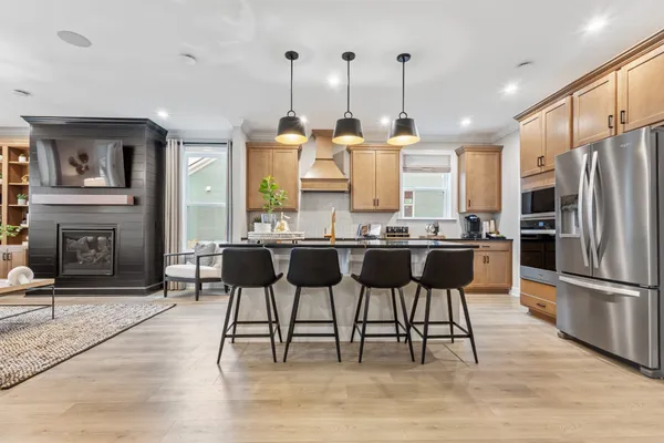 a kitchen with stainless steel appliances kitchen island granite countertop a dining table chairs and granite counter tops