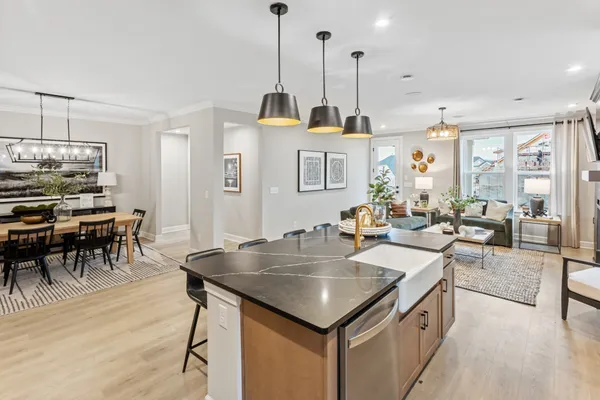 a kitchen with stainless steel appliances granite countertop a sink a stove and a wooden floors