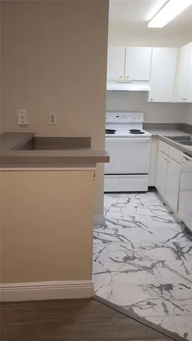 a kitchen with a refrigerator and white cabinets