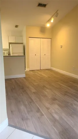 a view of a kitchen with wooden floor and electronic appliances