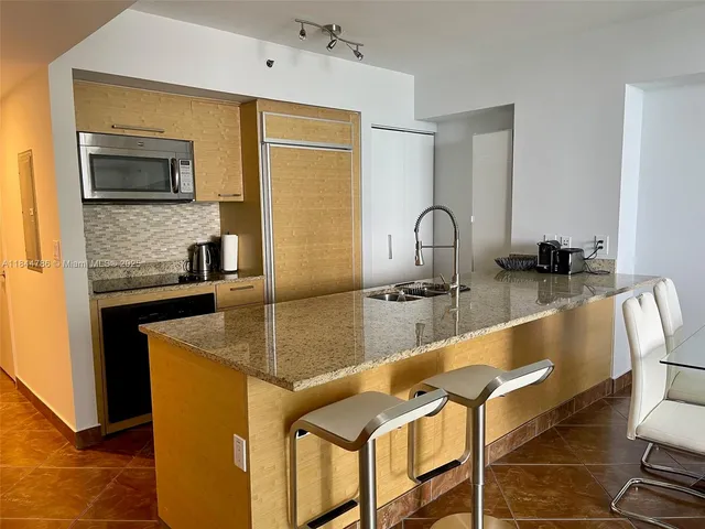 a kitchen with granite countertop a sink and a stove