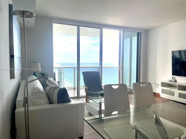 a living room with furniture and floor to ceiling window